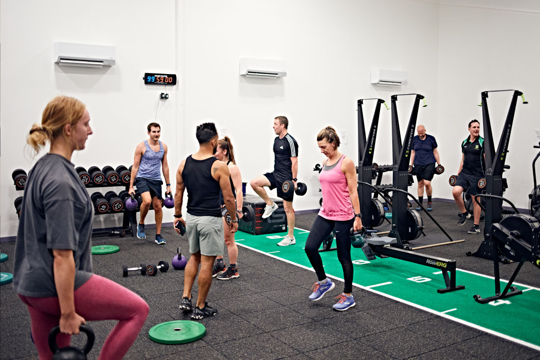 People exercising using various equipment in the performance suite