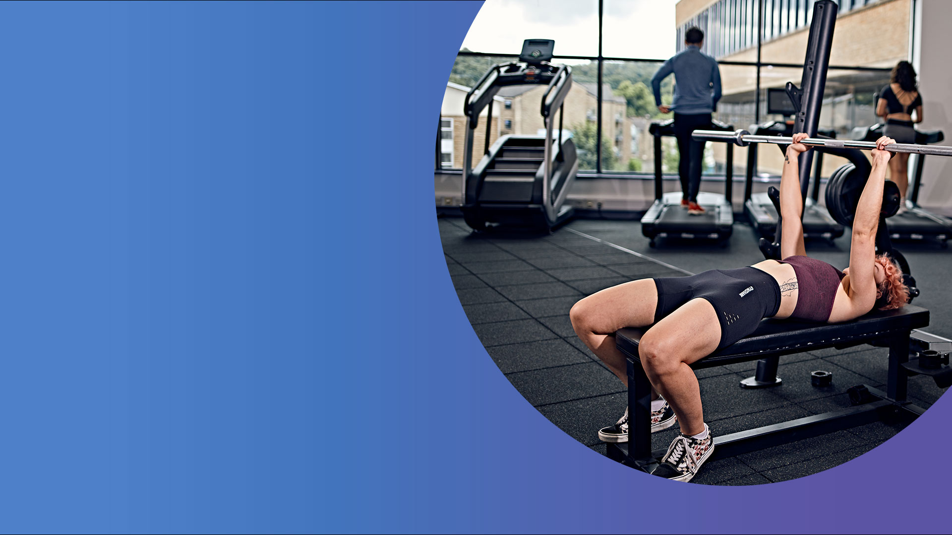 Student raising bar with others on treadmill in background