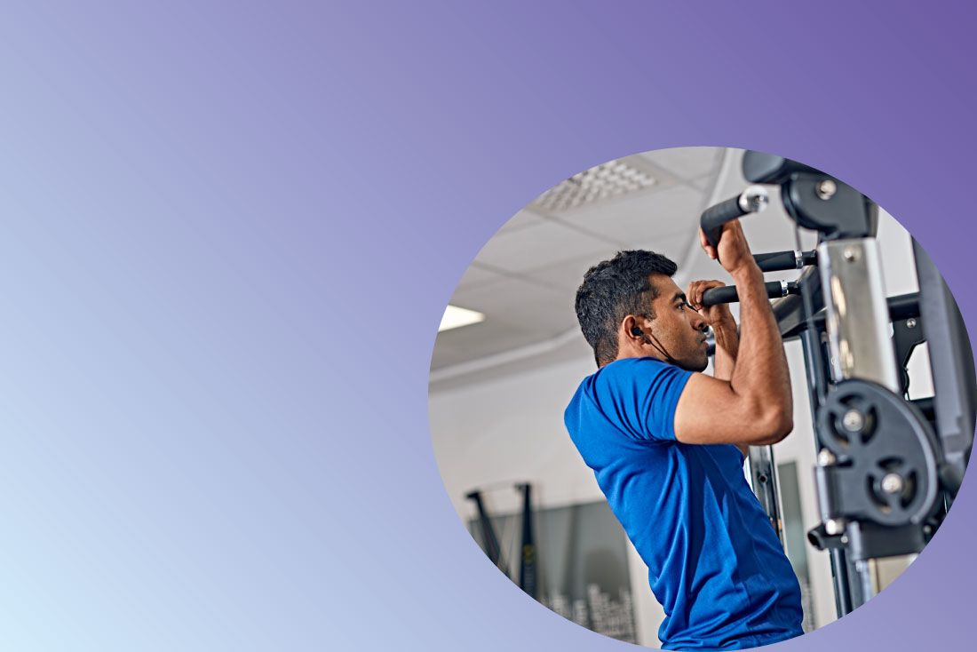 Student exercising with pull up machine in gym